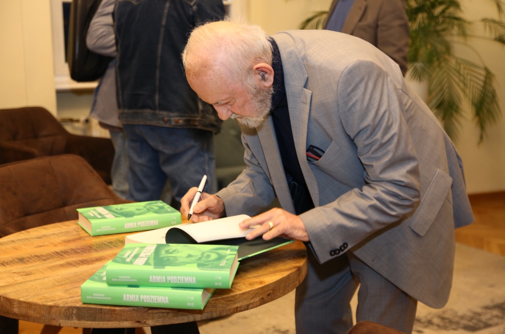 Adam Komorowski signing copies of the book